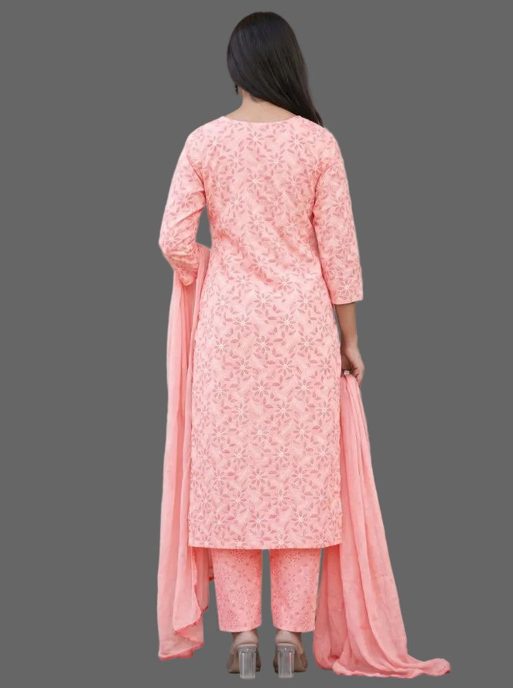 A woman viewed from behind wearing a light pink floral printed salwar kameez suit with matching pants and a long dupatta, standing in front of a white stone staircase.