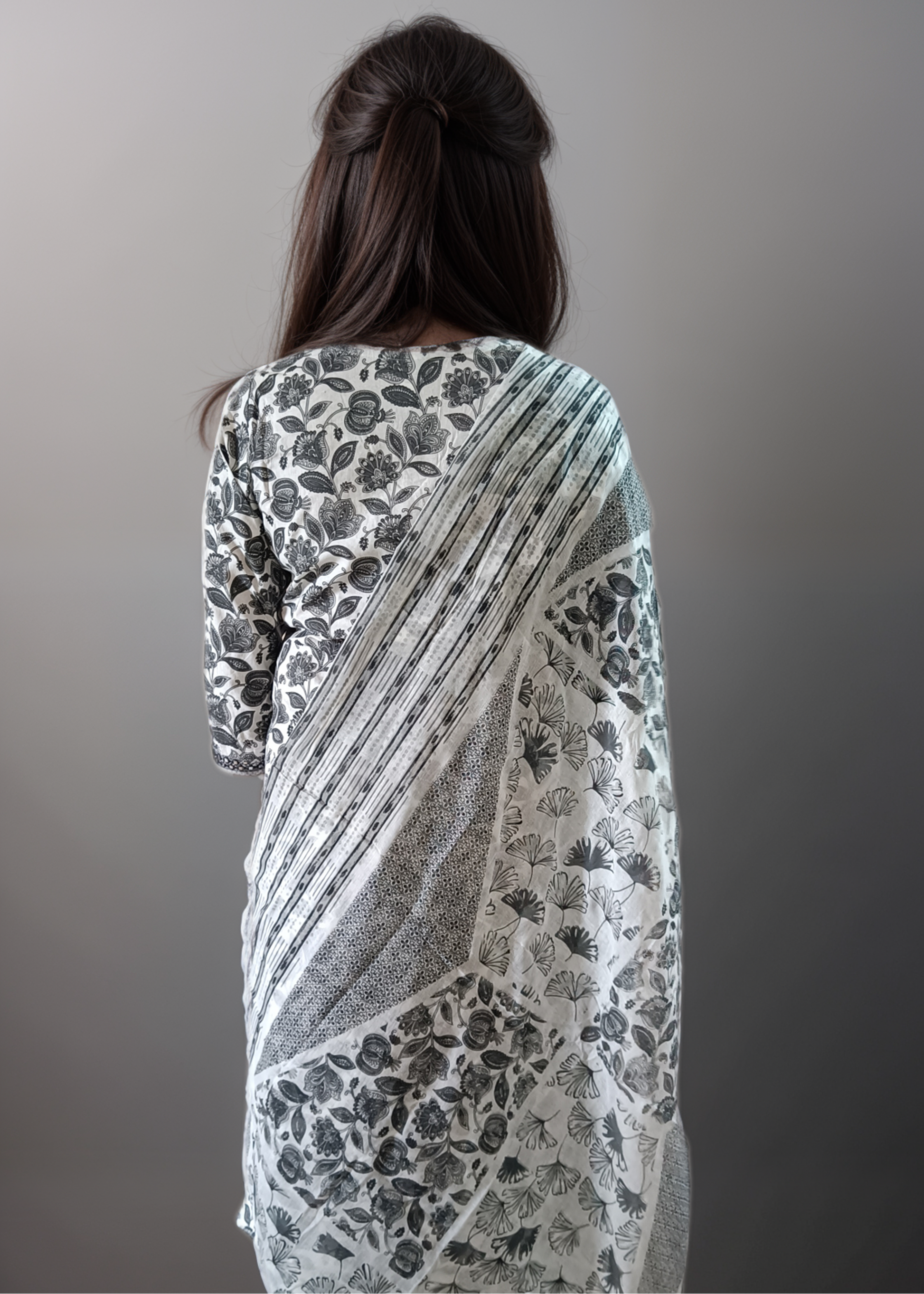 Woman wearing a floral salwar kurta set against a plain background