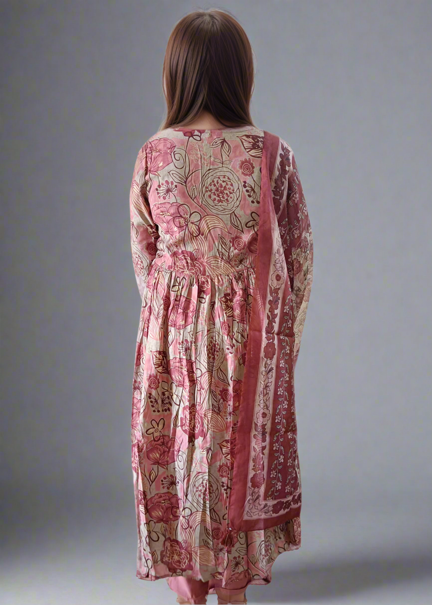 Woman wearing a pink patterned suit set dress with a plain background