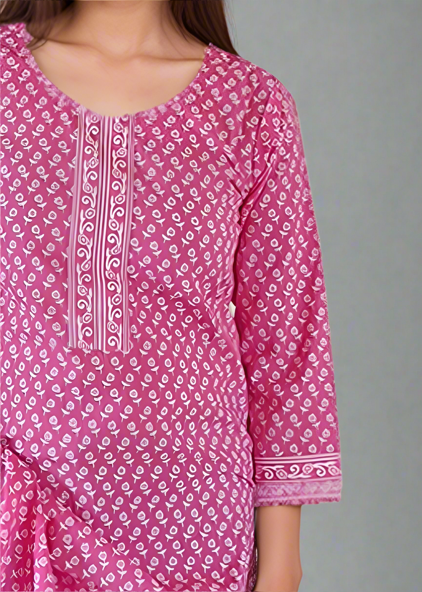Pink patterned dress worn by a person on a plain background