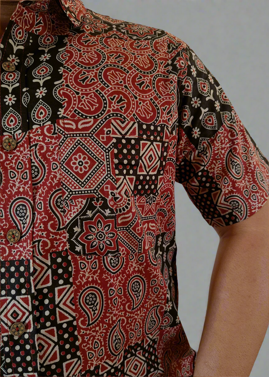 Close-up of a patterned shirt with red, black, and white design.