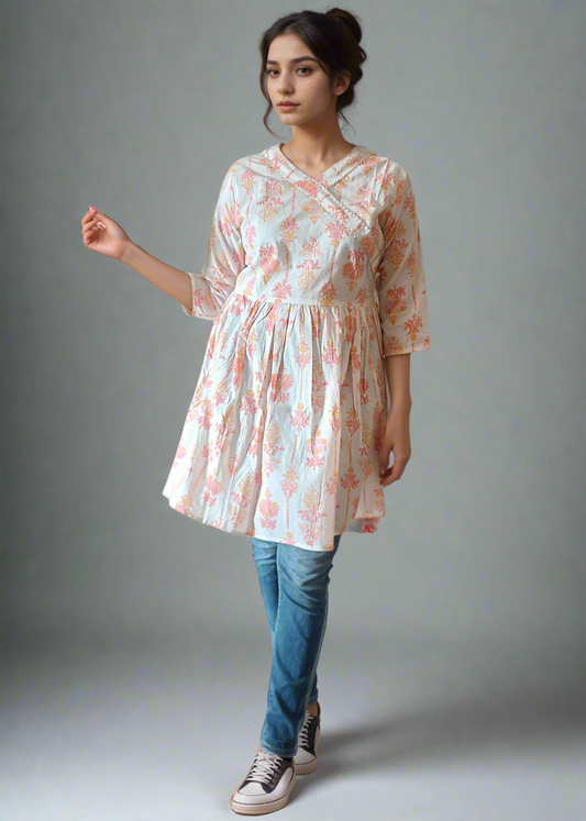 Woman wearing a floral dress over jeans against a plain background