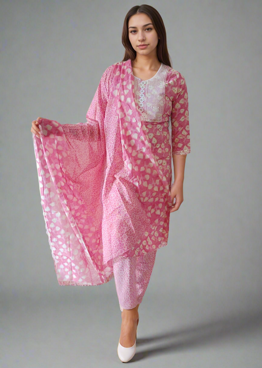 Woman wearing a pink floral salwar suit kurta set with a white background