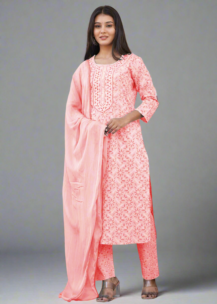 Woman wearing a pink traditional outfit with a dupatta, standing on a decorative staircase.