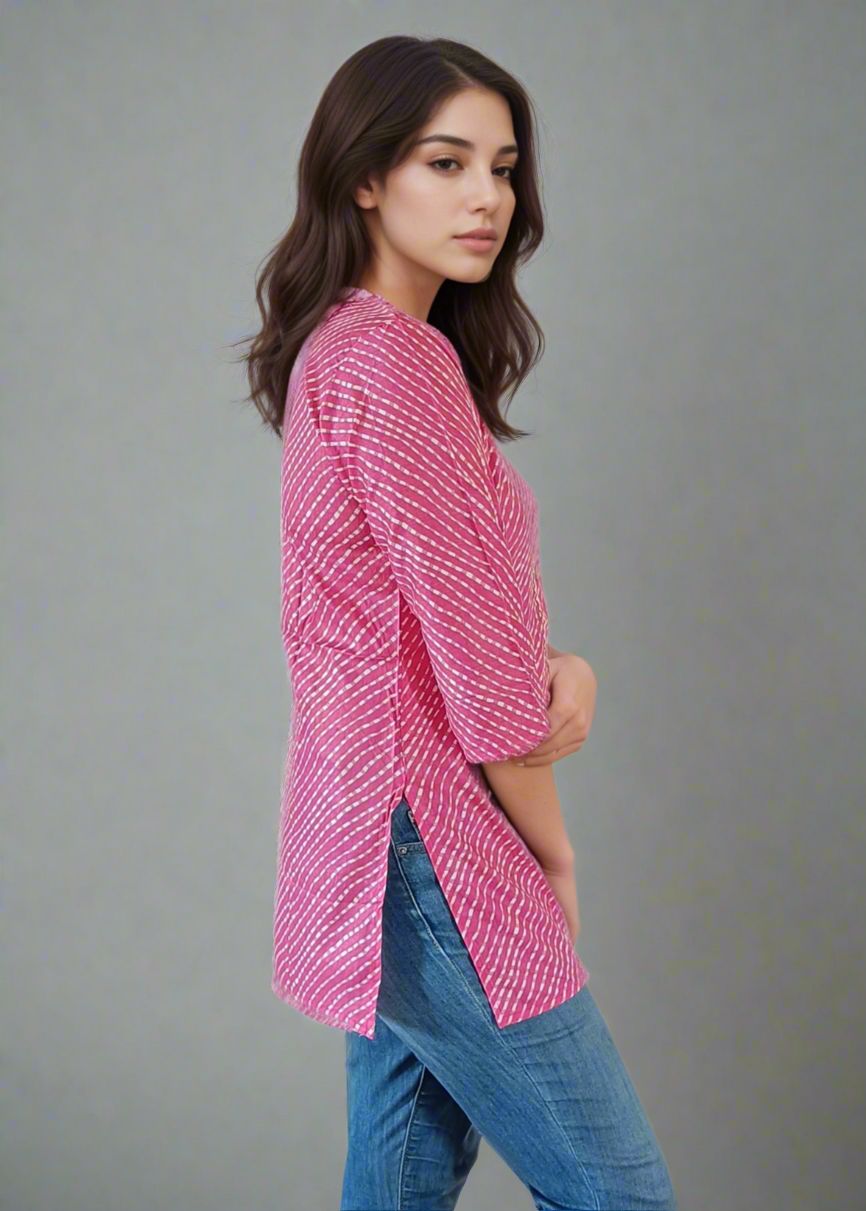 Woman wearing a pink patterned shirt and blue jeans on a white background