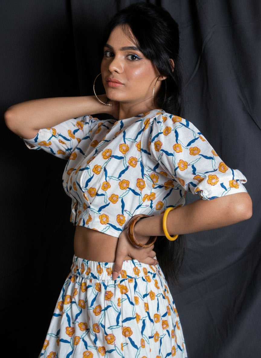 Woman wearing a white blouse with orange floral patterns against a dark background