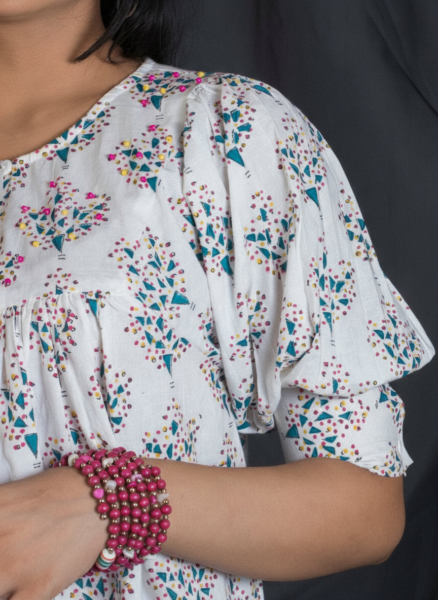 Woman wearing a floral dress with a puffed sleeve detail