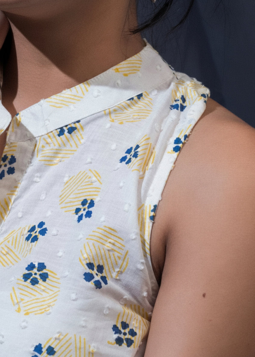 Close-up of a person wearing a sleeveless top with a floral pattern.
