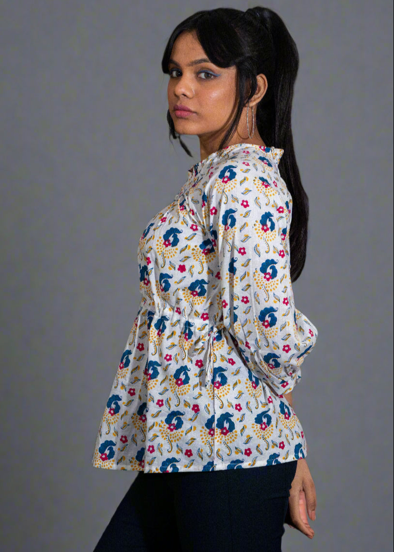 Woman wearing a hand block floral paisley blouse against a dark background
