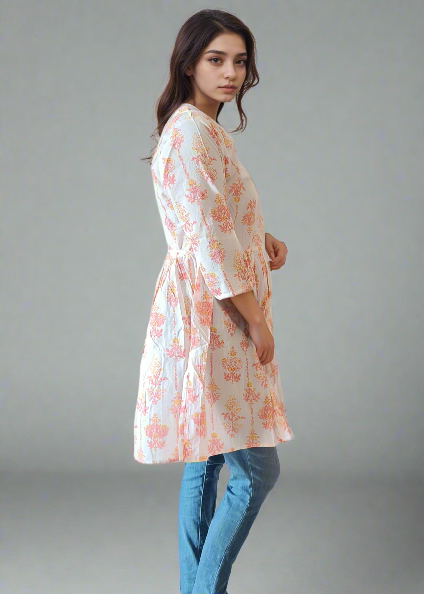 Woman wearing a floral dress and blue jeans on a plain background