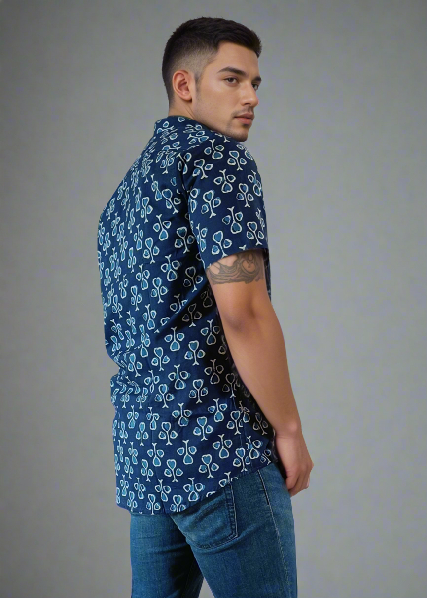 Man wearing a blue patterned shirt and jeans on a white background
