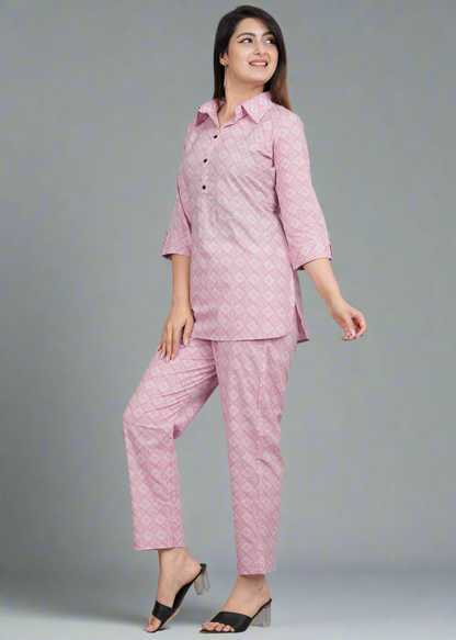 Woman wearing a pink patterned outfit on a gray background