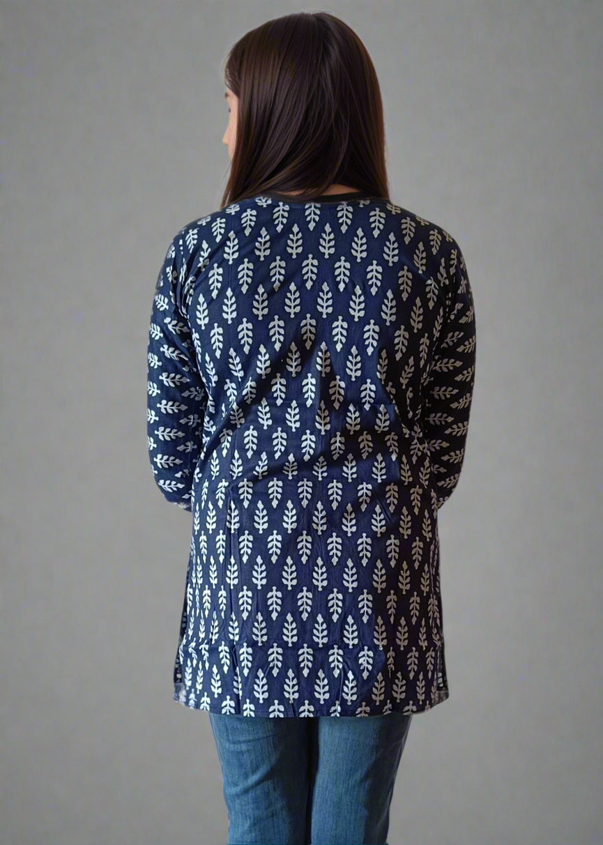 Woman wearing a blue patterned tunic kurti and jeans on a plain background