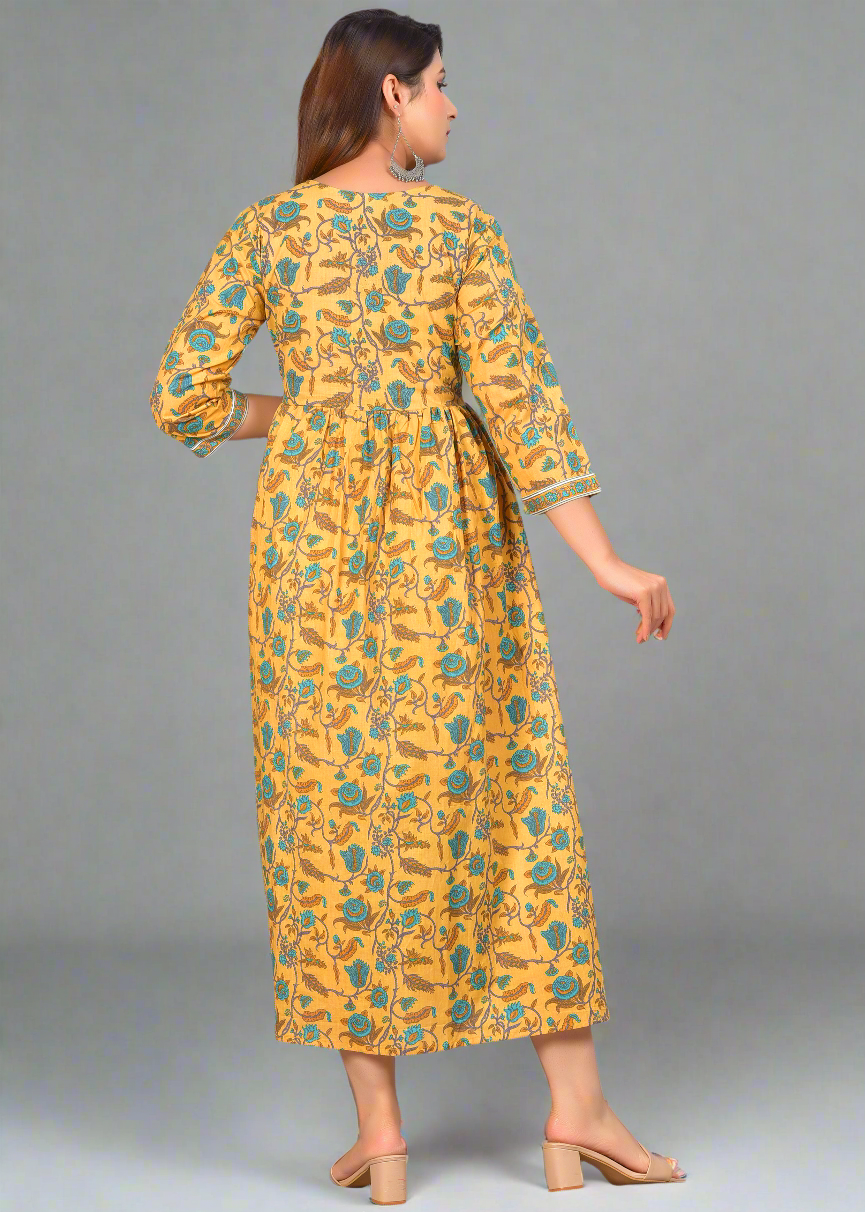 Woman wearing a yellow dress with green floral pattern on a gray background