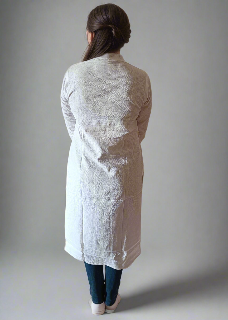 Person wearing a white textured long kurta against a plain background