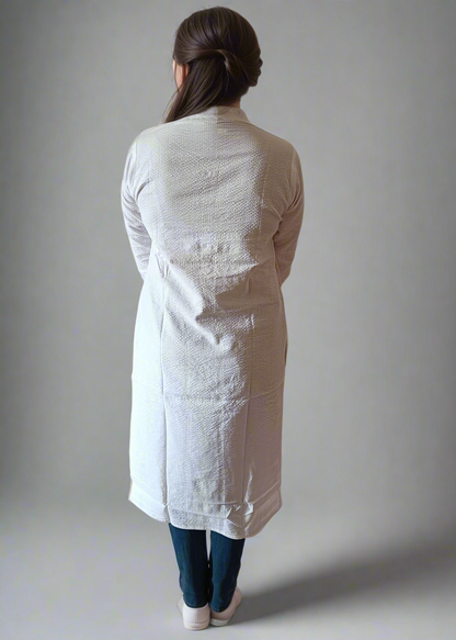 Person wearing a white textured long kurta against a plain background