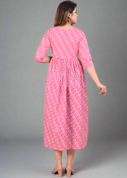 Woman wearing a pink dress with white patterns, standing on a beige background.