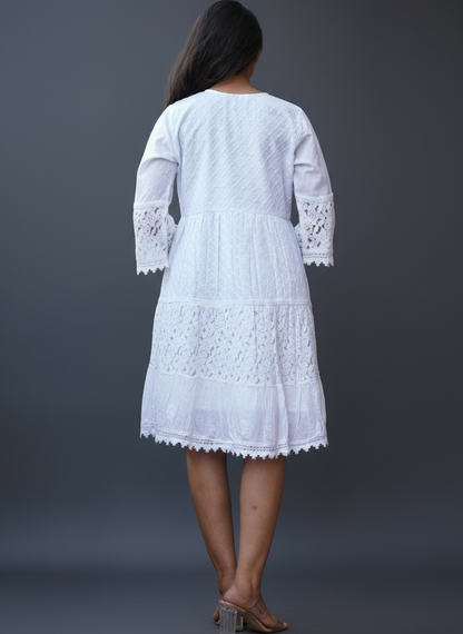 Woman wearing a white embroidered dress with lace and schiffly fabric