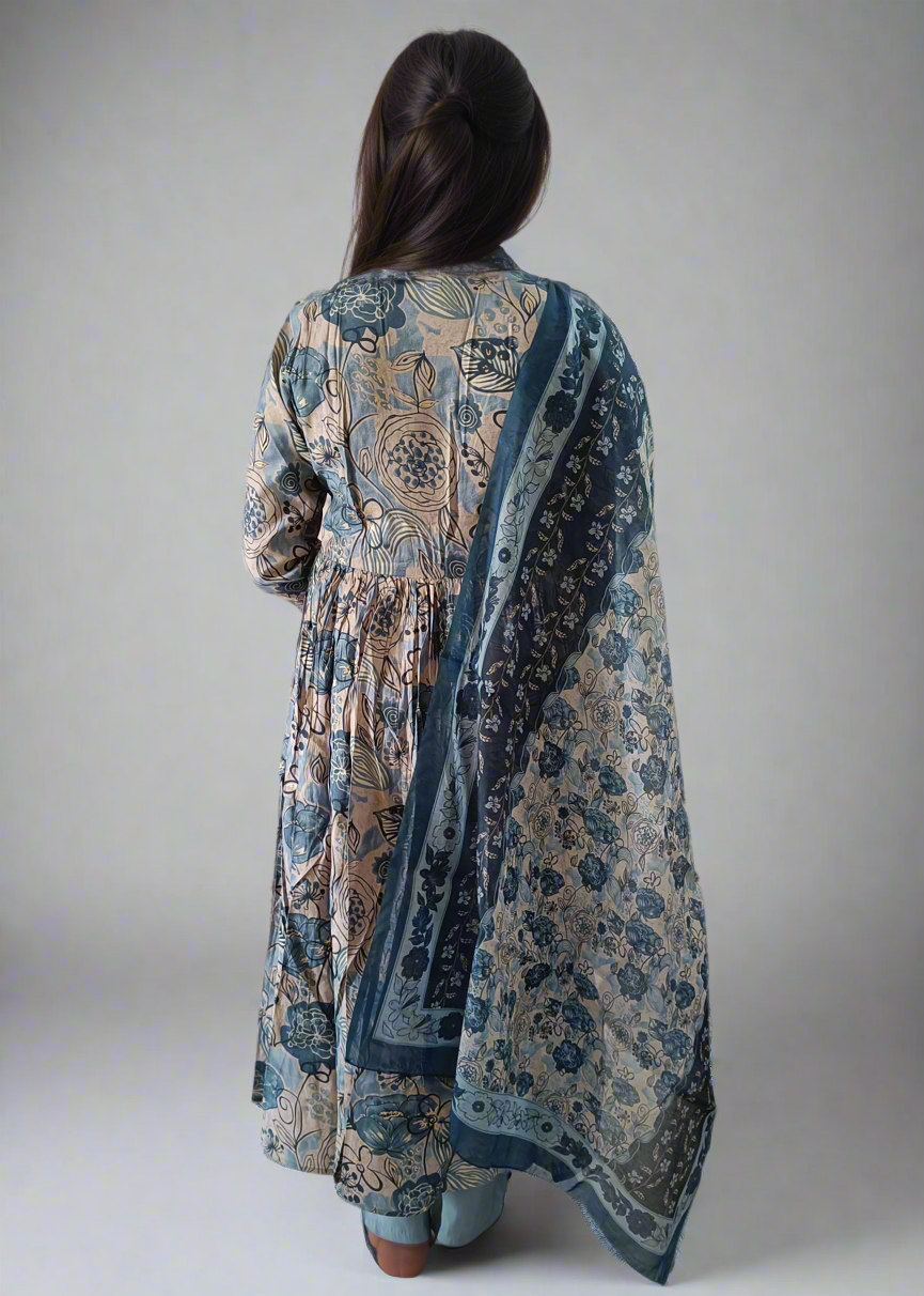 Woman wearing a long, patterned floral suit set dress with matching dupatta on a white background
