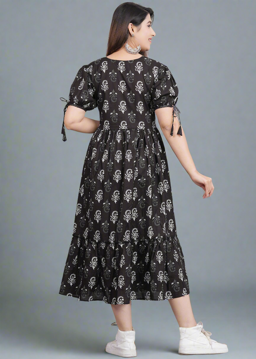 Woman wearing a black dress with white patterns on a gray background