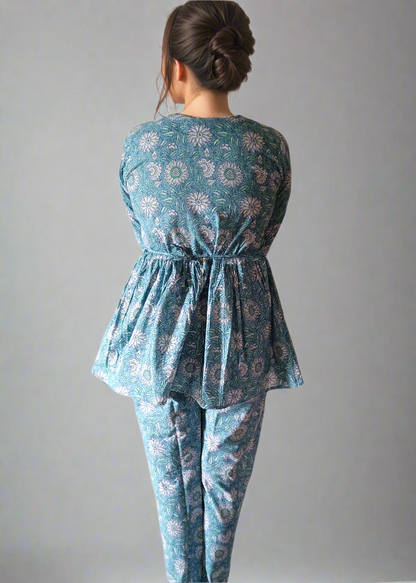 Woman wearing a blue patterned outfit on a plain background
