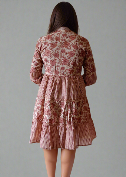 Woman wearing a floral stripe dress against a plain background