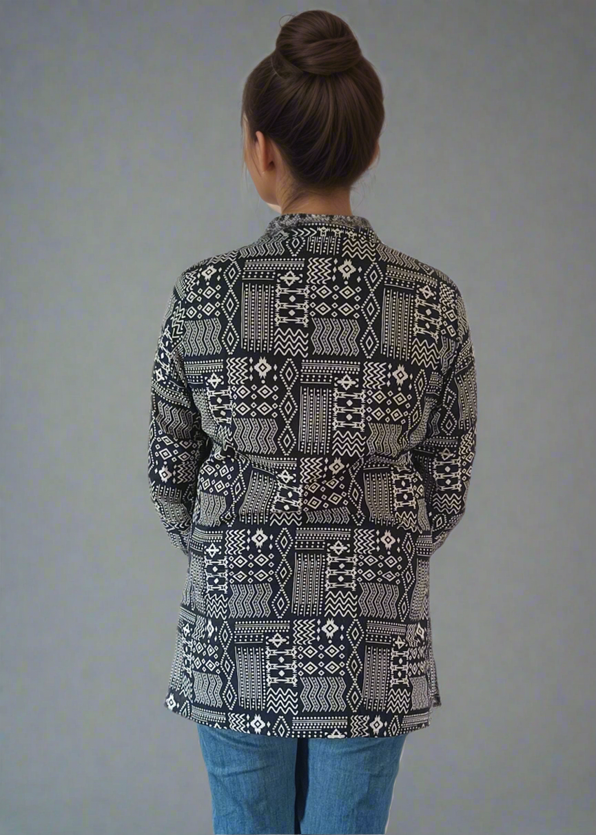 Person wearing a patterned tunic kurti top and blue jeans on a plain background