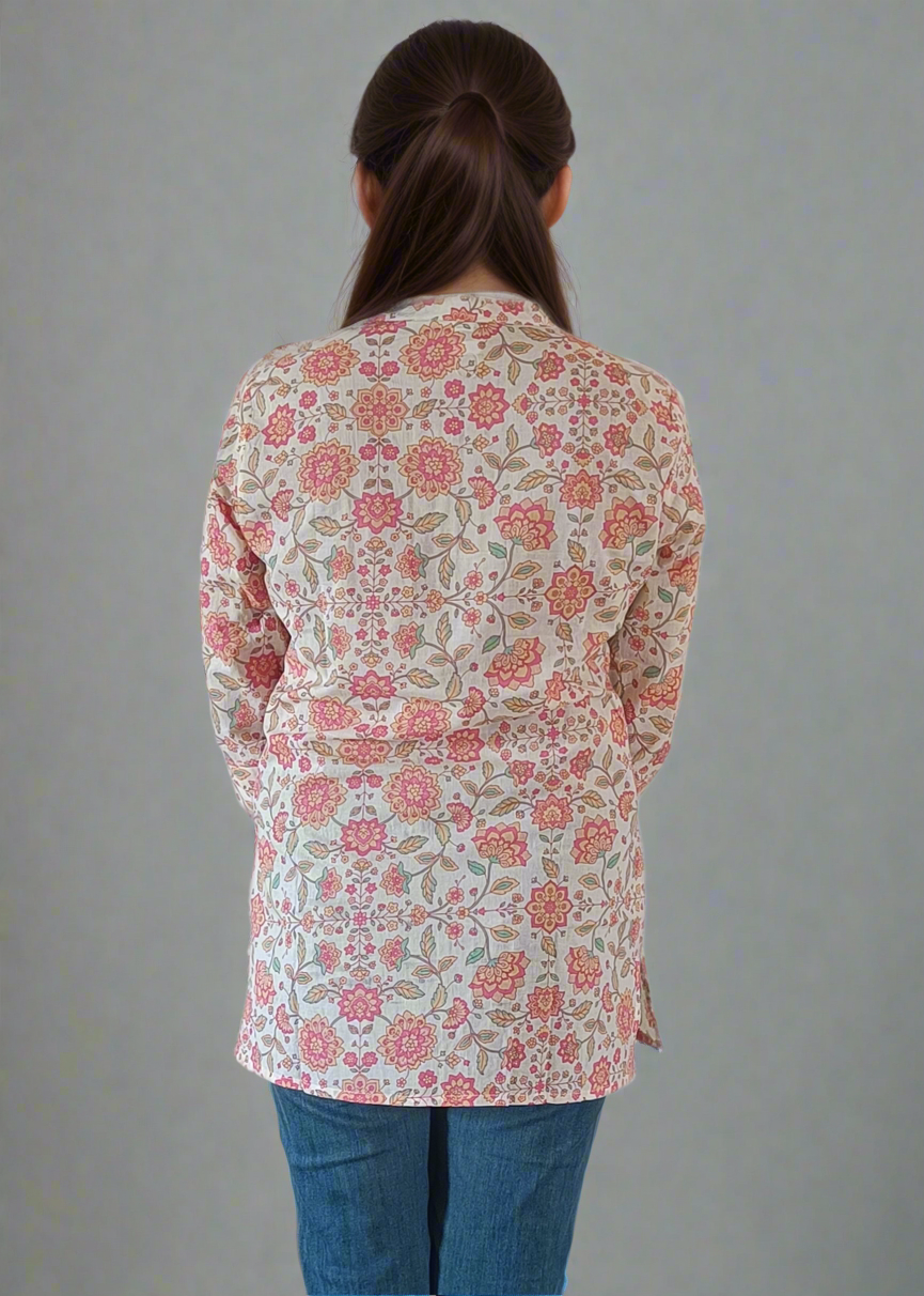 Person wearing a floral blouse and blue jeans on a plain background