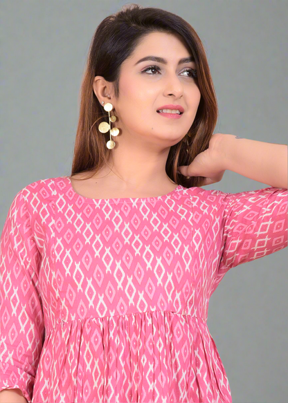 Woman wearing a pink patterned maternity dress against a beige background