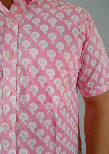 Pink shirt with white floral pattern worn by a person