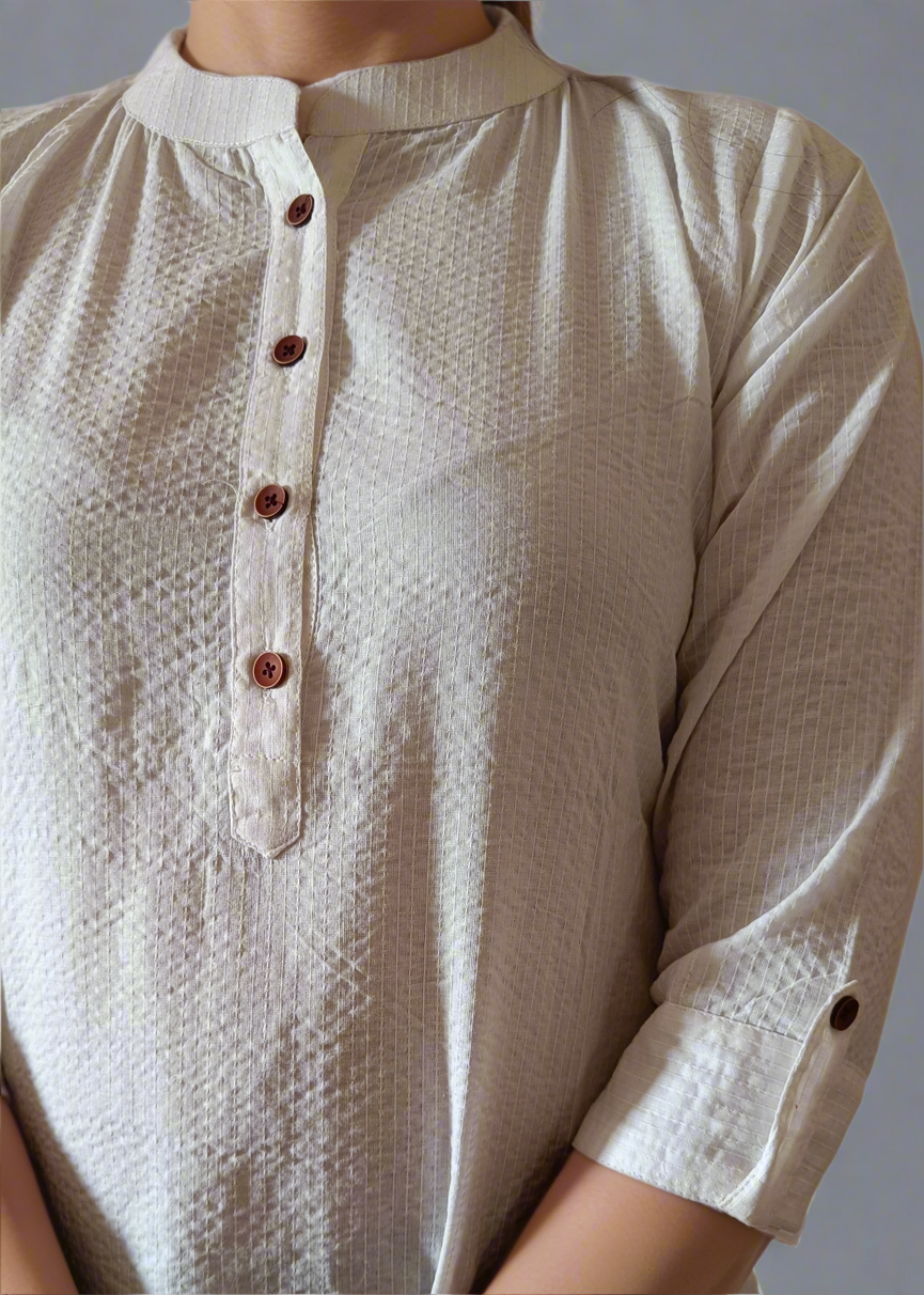 Close-up of a beige textured shirt with buttons on a neutral background
