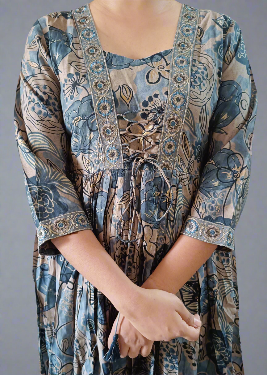 Woman wearing a long, patterned floral suit set dress on a white background