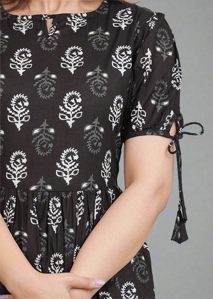 Black dress with white floral patterns on a gray background