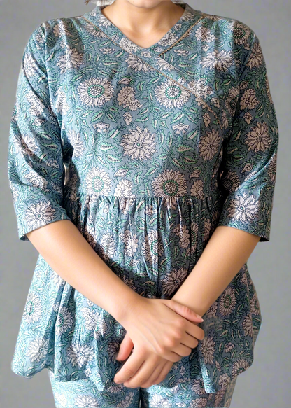 Person wearing a blue floral co-ord set against a plain background