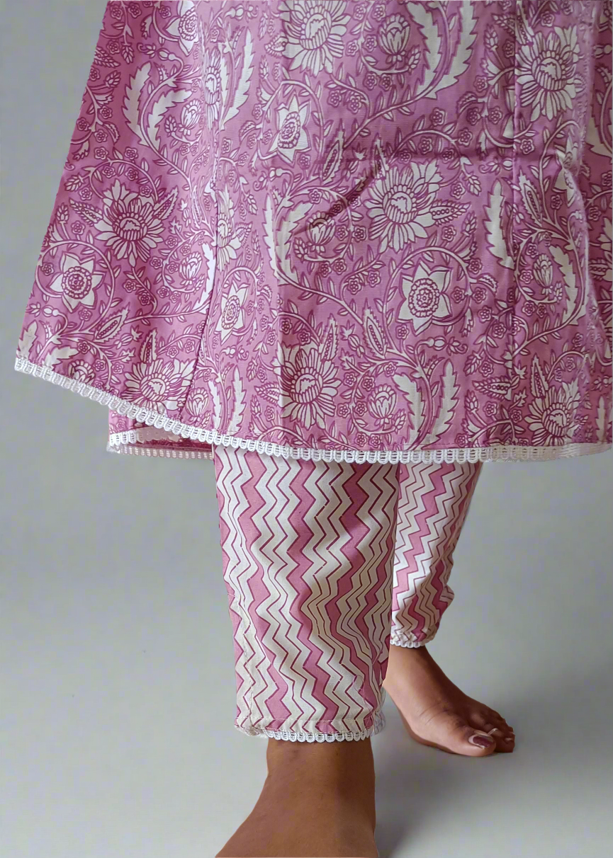 Pink and white patterned outfit on a neutral background