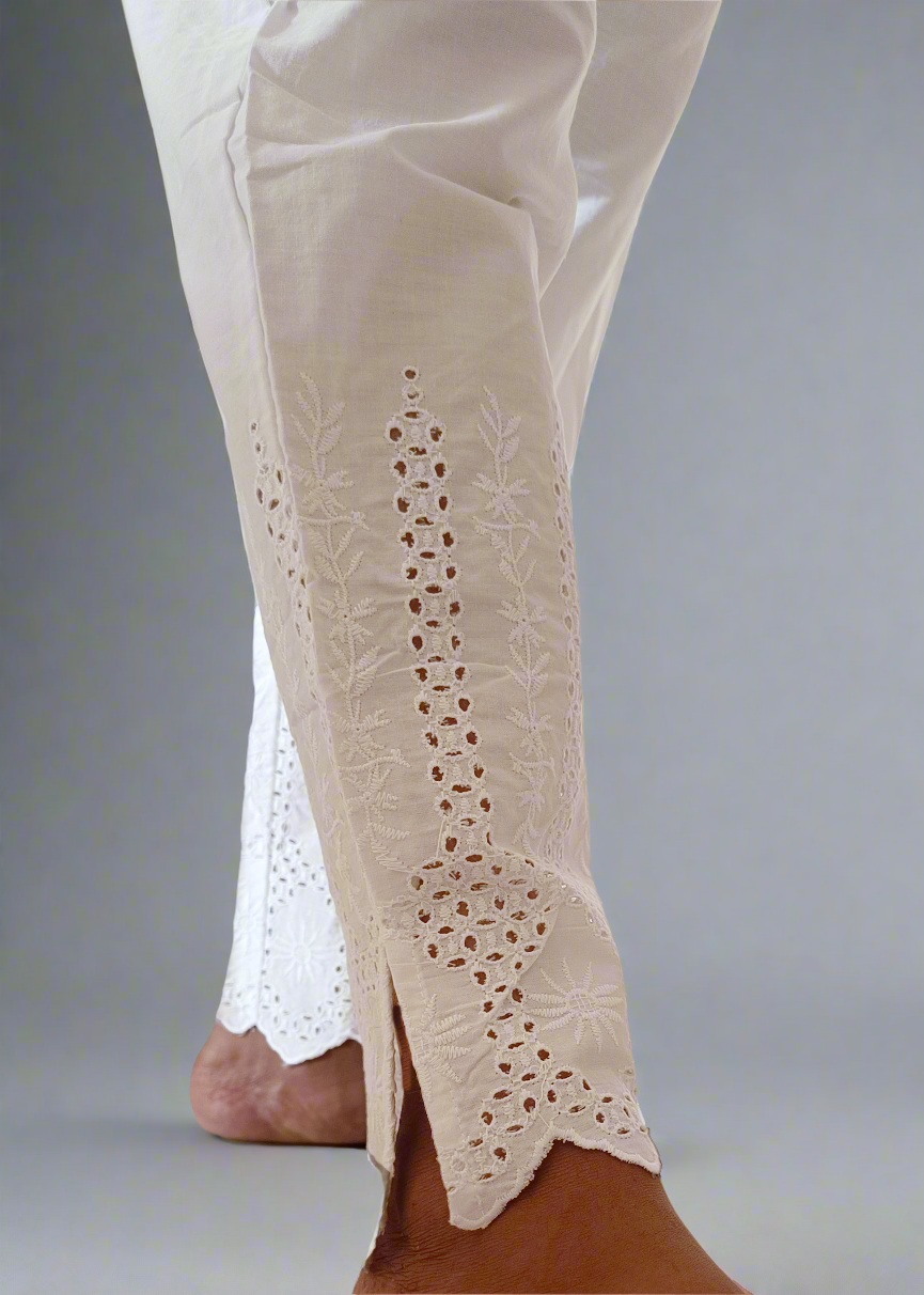 White pants with lace detailing on a neutral background