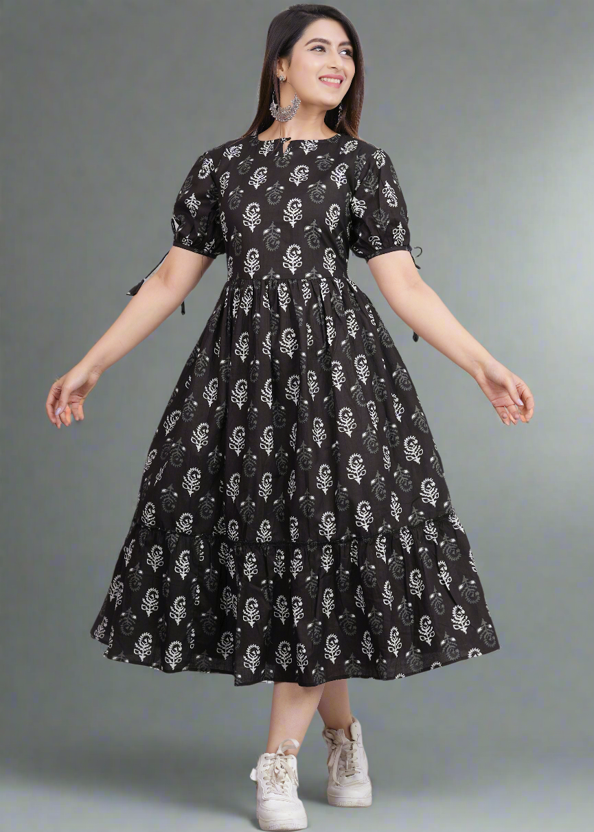 Woman wearing a black dress with white patterns on a gray background