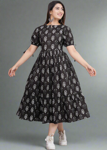 Woman wearing a black dress with white patterns on a gray background