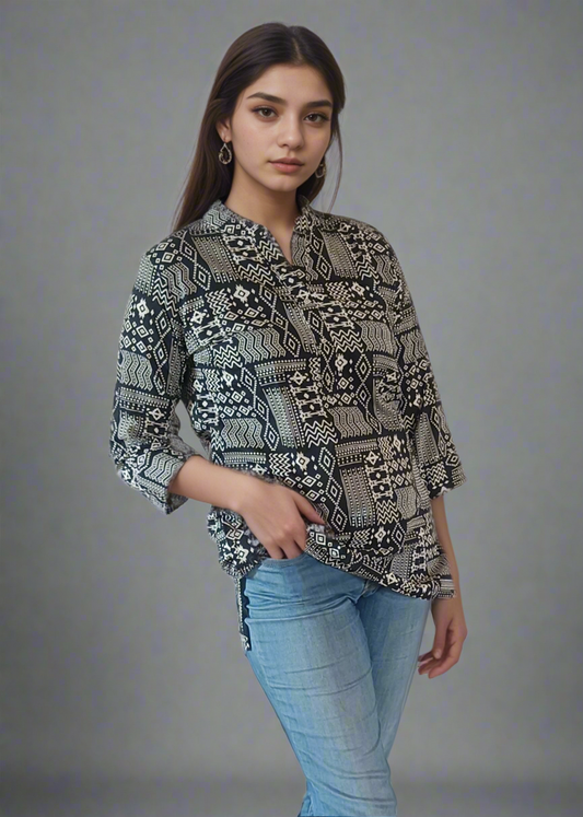Woman wearing a patterned shirt, blue jeans, and white sneakers on a plain background