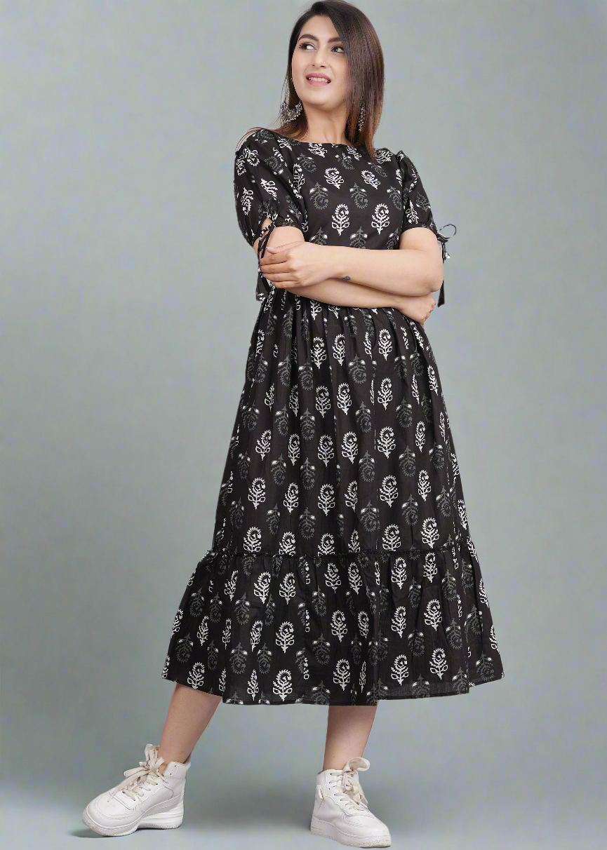 Woman wearing a black dress with white patterns on a gray background