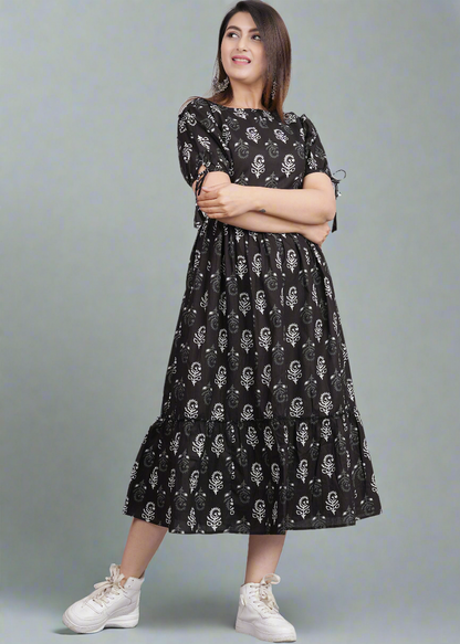Woman wearing a black dress with white patterns on a gray background
