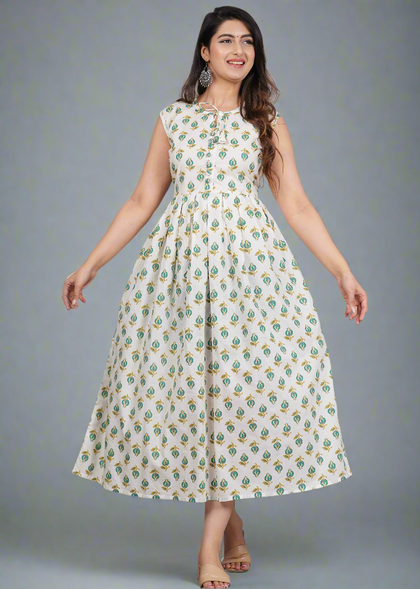 Woman wearing a white dress with green floral pattern on a gray background