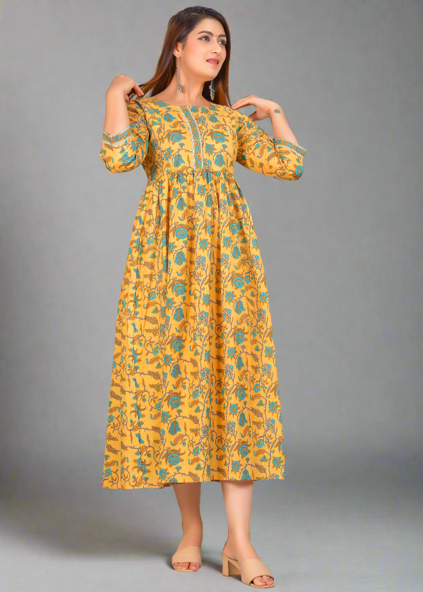 Woman wearing a yellow floral nursing dress with invible zippers against a gray background