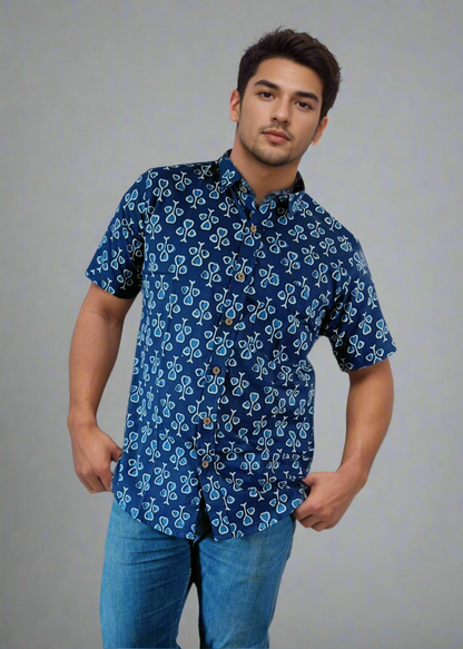 Man wearing a blue floral shirt and jeans against a white background