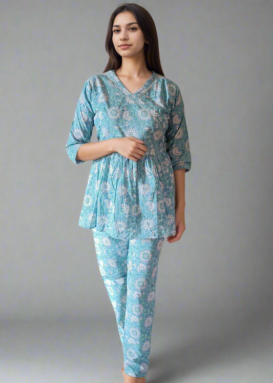 Woman wearing a blue floral pajama set against a plain background
