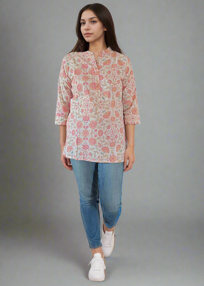Woman wearing a floral blouse and blue jeans on a plain background