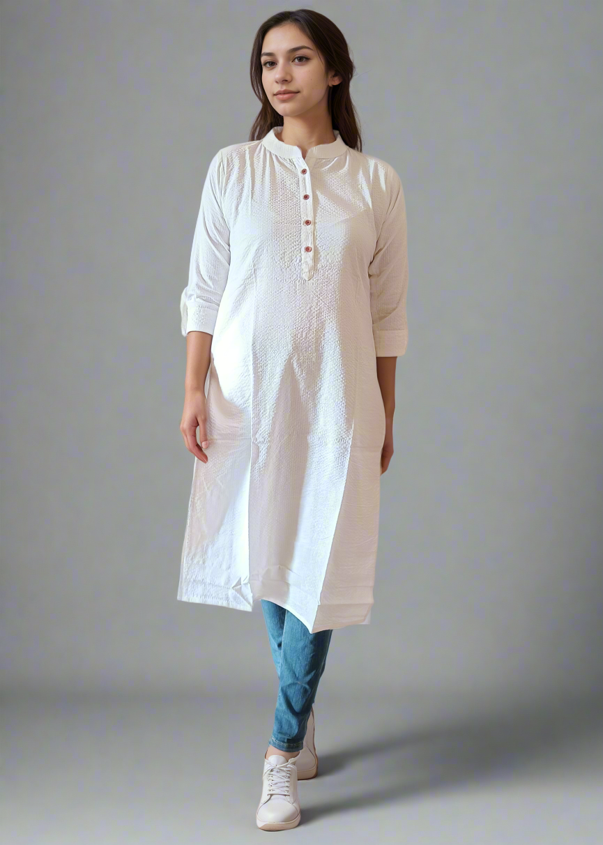 Woman wearing a white kurta with blue pants on a plain background