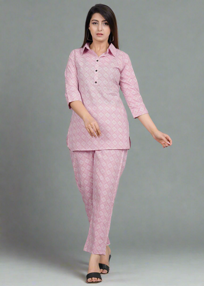 Woman wearing a pink traditional bandhani outfit with a pattern on a gray background