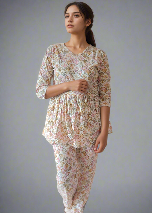 Woman wearing a floral pajama set against a plain background