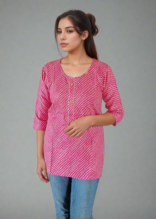 Woman wearing a pink patterned top and blue jeans on a plain background